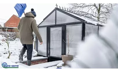 Erdgewächshaus im Winter mit schützender Erdumrandung