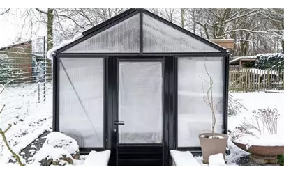 Erdgewächshaus im Schnee mit lichtdurchlässigem Glasdach